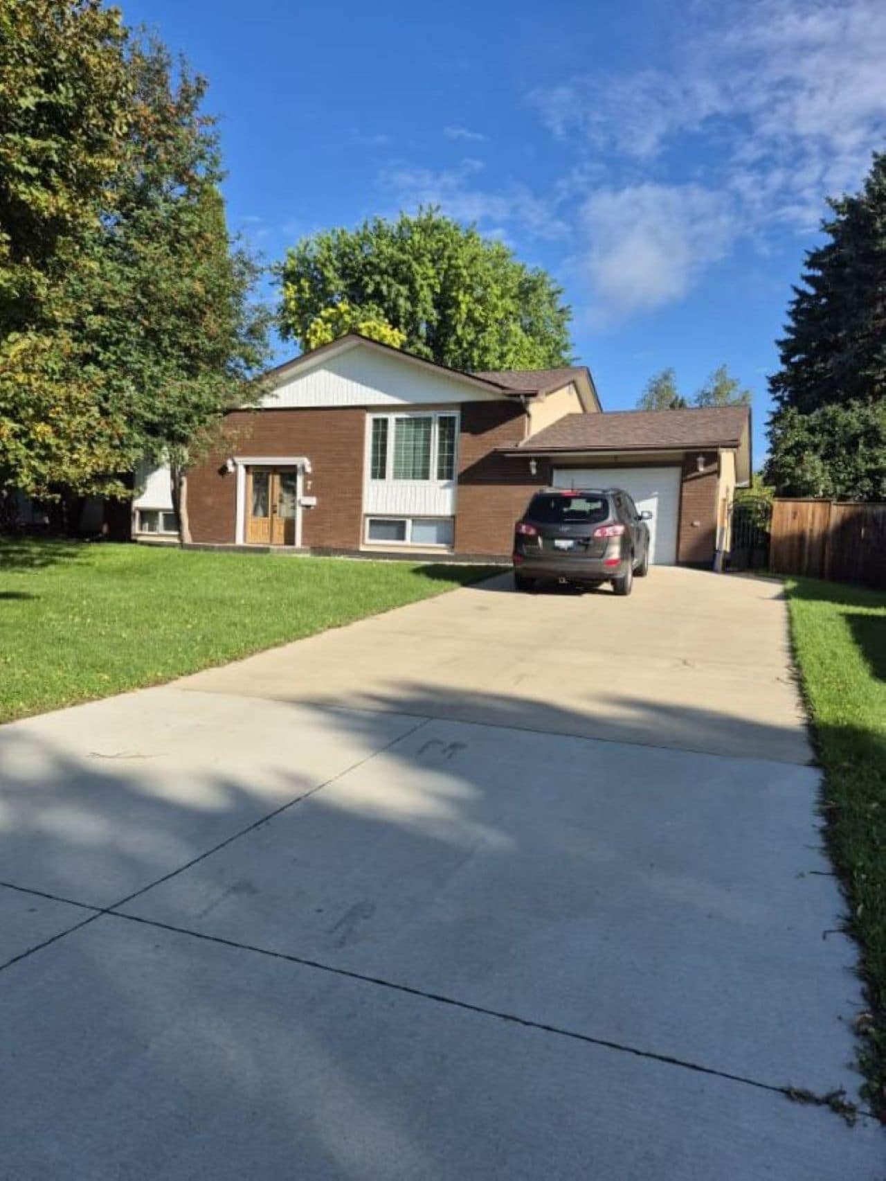 A two-story house with a garage, a driveway, and a lawn.