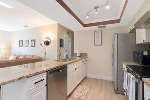 A modern kitchen with a central island, stainless steel appliances, and a built-in oven. - Spacious 2br-2ba townhome located in Saddlebrook (Zephyrhills)