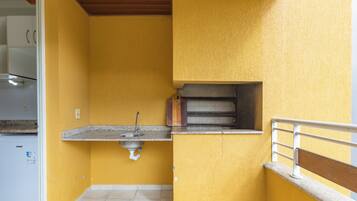A kitchen with a built-in oven, a sink, and a window.