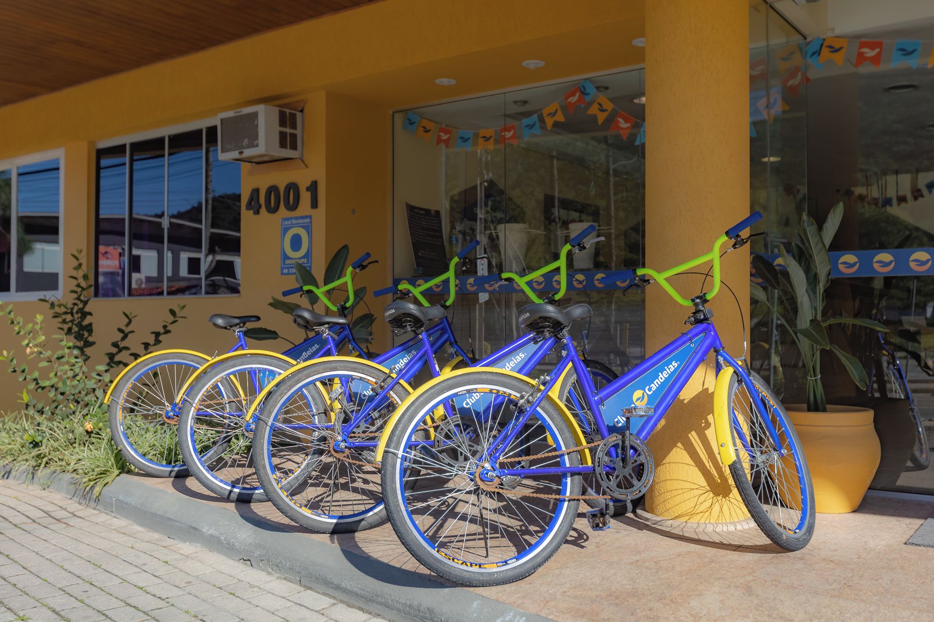 A row of bicycles parked outside a building with a yellow facade and the number 4001.