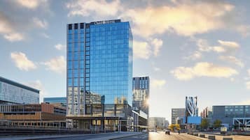 Un moderno edificio de hotel con fachada de vidrio y un letrero llamativo en la parte superior.
