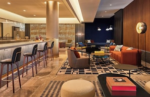Un espace de détente moderne doté d’un bar, de sièges et d’un sol à motifs.