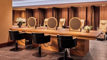 Een moderne bar met een houten toonbank, meerdere spiegels en zwarte barstoelen.