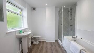 A modern bathroom with a shower, toilet, and sink.