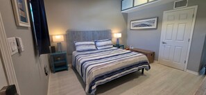 A bedroom with a bed, bedside lamps, a nightstand, a door, and a wall-mounted picture. - Hidden Gem One of Port A’s best-kept secrets (Port Aransas)