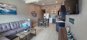 Un salon moderne avec un canapé, une table basse et un coin repas.