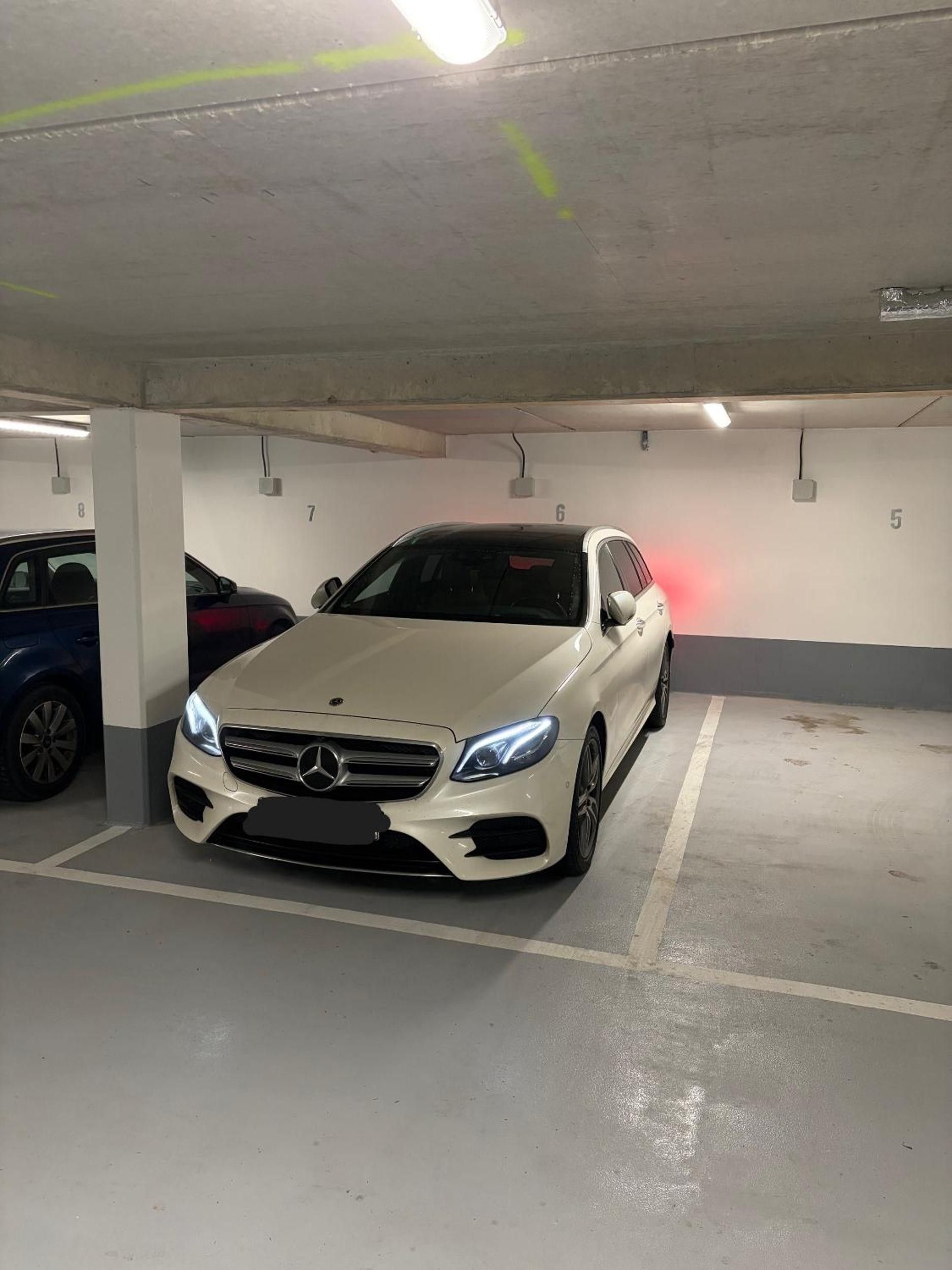 Un parking où une voiture blanche est garée dans un espace réservé à cet effet.