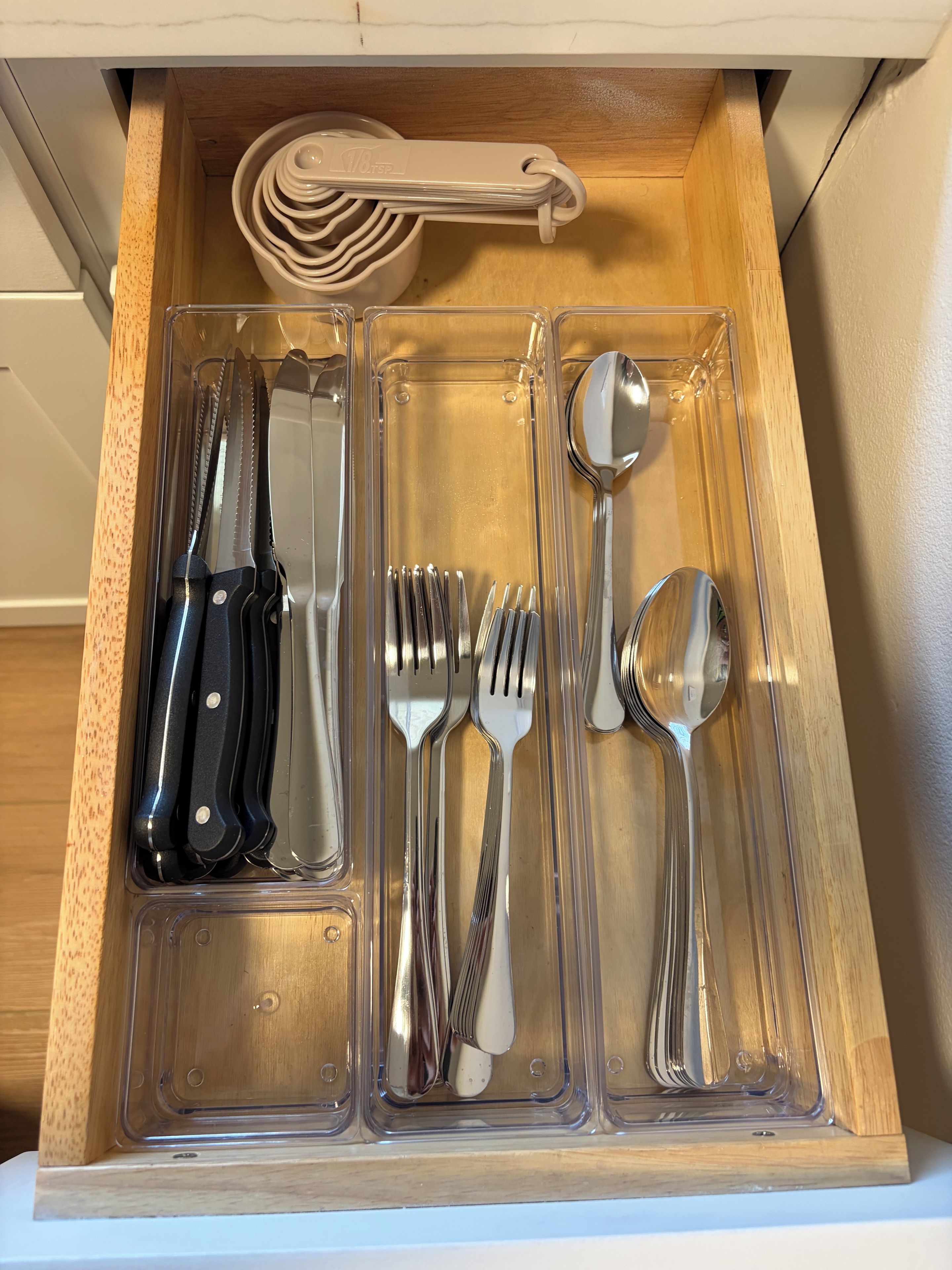 A drawer with utensils including knives, forks, and spoons.