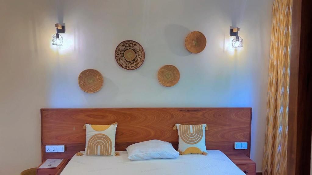 A hotel room with a wooden headboard, two bedside tables, and a bed with patterned pillows.