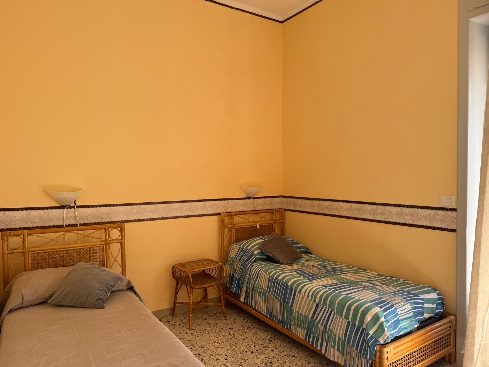 Un alojamiento pequeño y de una sola habitación con dos camas, una mesita y una silla.