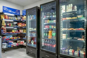 A refrigerated display with various beverages and snacks. - You Faria Lima (São Paulo)