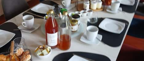 A dining table set with plates, cups, and various food items, indicating a meal setup.