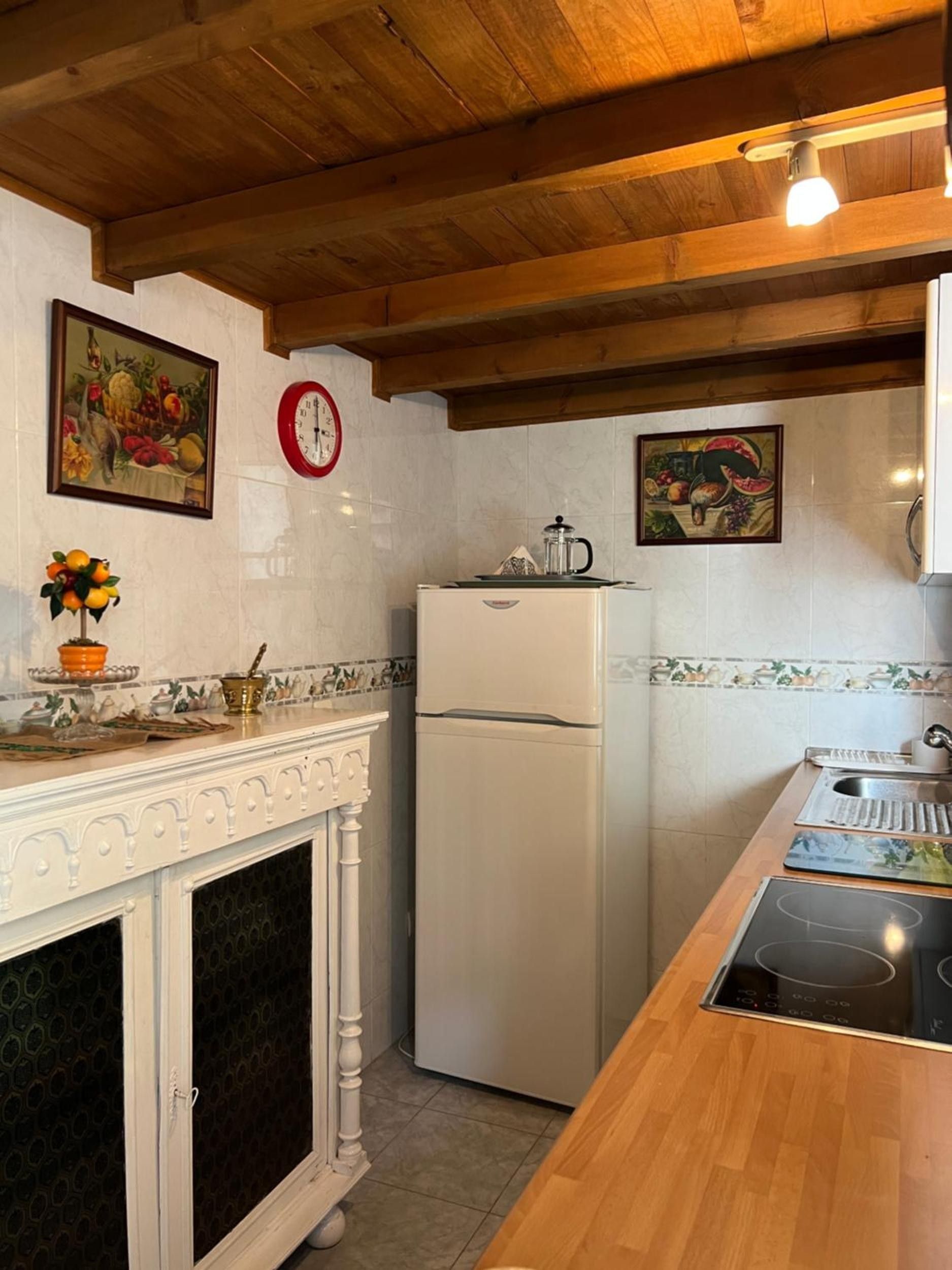 Una cucina con frigorifero bianco, fornello, lavello e decorazioni a parete.