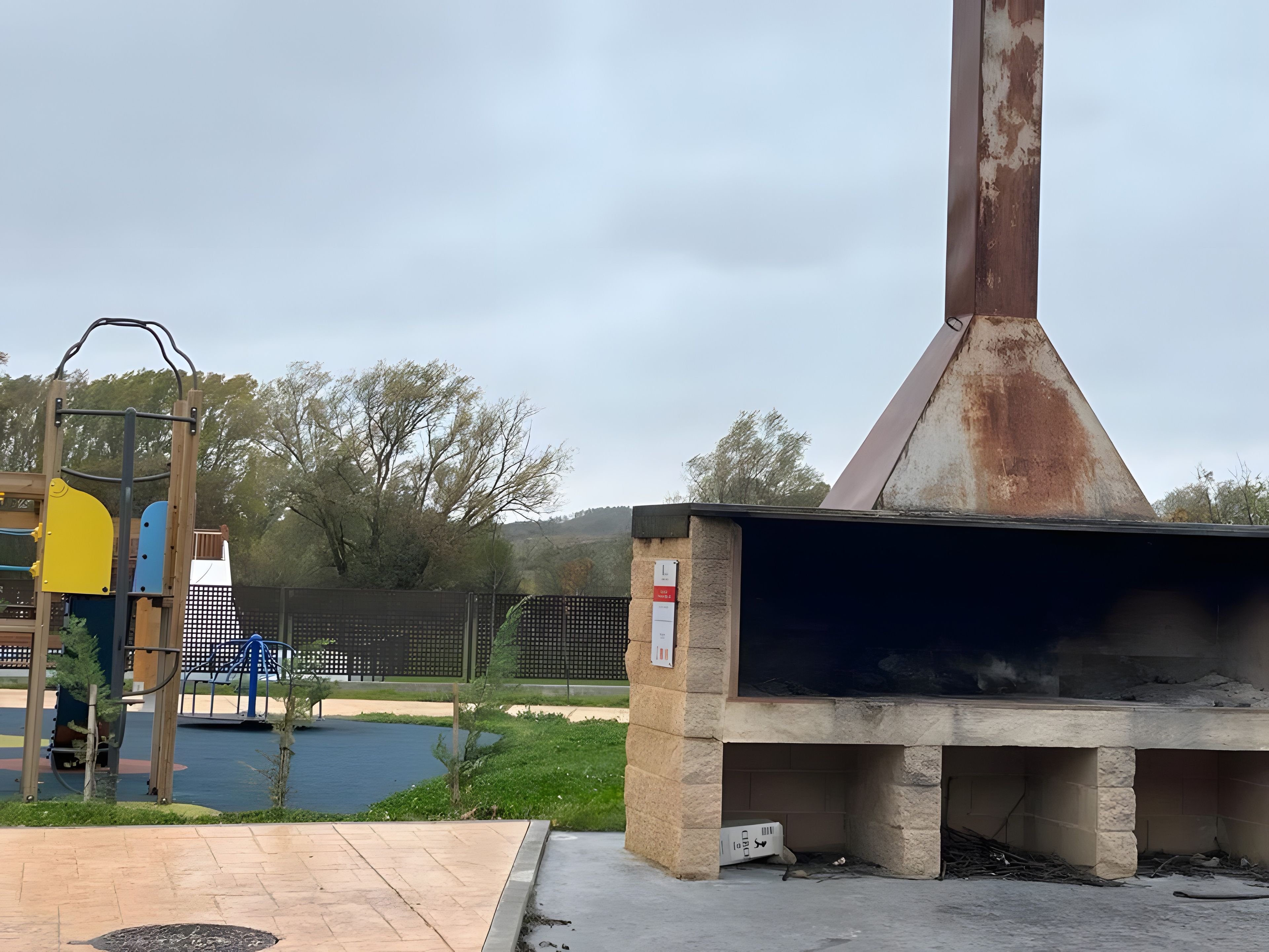 Un terrain de jeux équipé de structures d’escalade et d’un espace barbecue.
