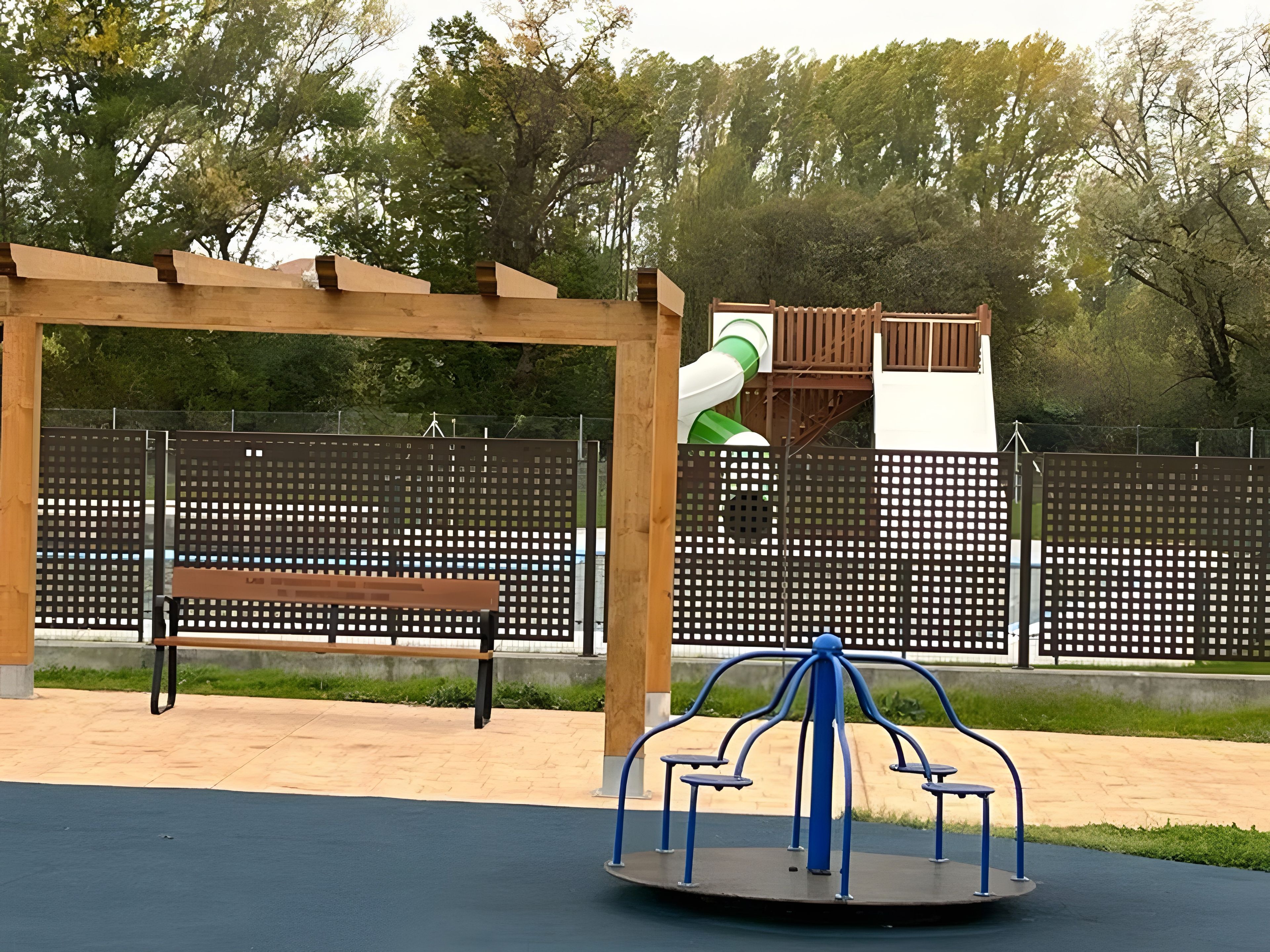 A playground with a swing set, a slide, and a bench.