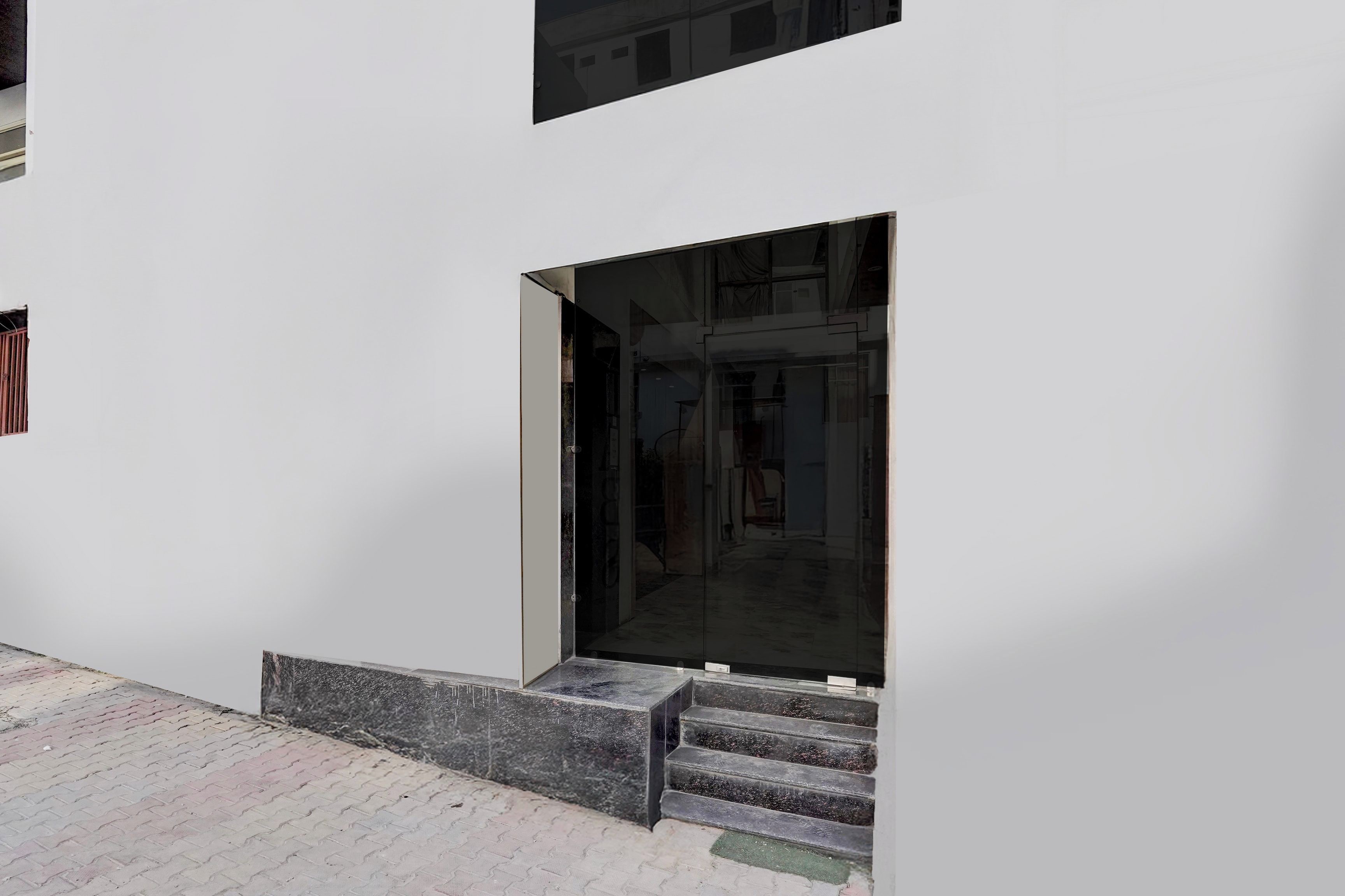 A modern building entrance with a glass door and a set of concrete steps leading up to it.