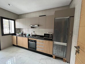 Eine moderne Küche mit Einbauofen, Mikrowelle und einem Edelstahl-Kühlschrank.