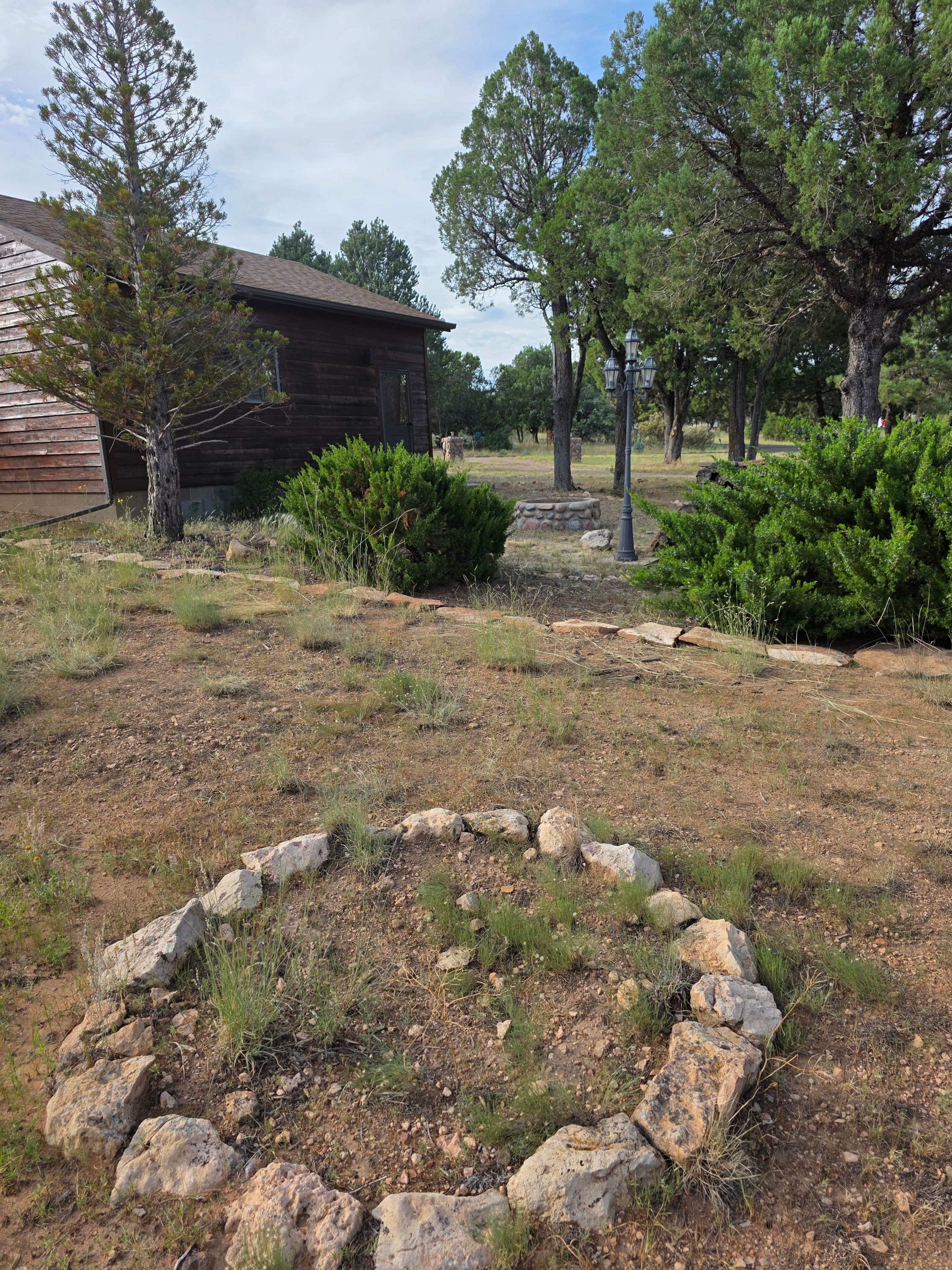 A rustic cabin with a stone fire pit in the foreground.