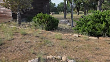 A rustic cabin with a stone fire pit in the foreground.