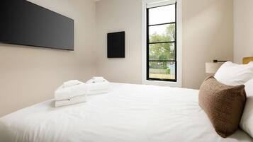Ein Hotelzimmer mit einem Bett, einem Fenster und einer Wand-Klimaanlage.