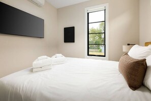 Ein Hotelzimmer mit einem Bett, einem Fenster und einer Wand-Klimaanlage.