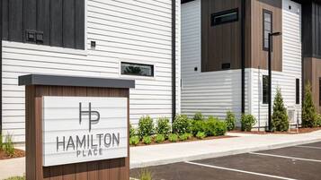 Ein modernes Gebäude mit einem Schild, auf dem 'Hamilton Place' steht, und einem Parkplatz davor.