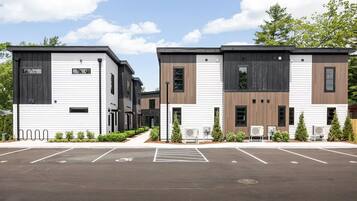 Un bâtiment moderne avec un parking situé à l’avant.
