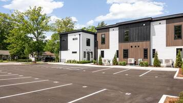 A modern building with a parking lot in front.