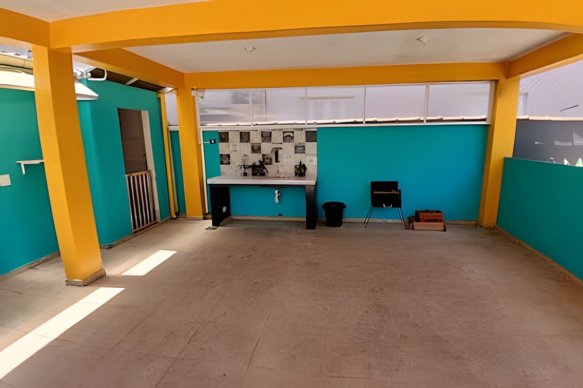 A spacious room with teal walls, a yellow ceiling, and a tiled backsplash.