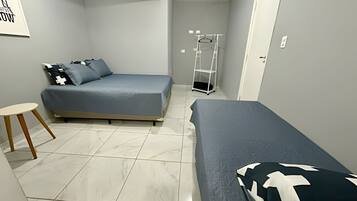 A small, modern bedroom with a bed, a chair, and a wardrobe.
