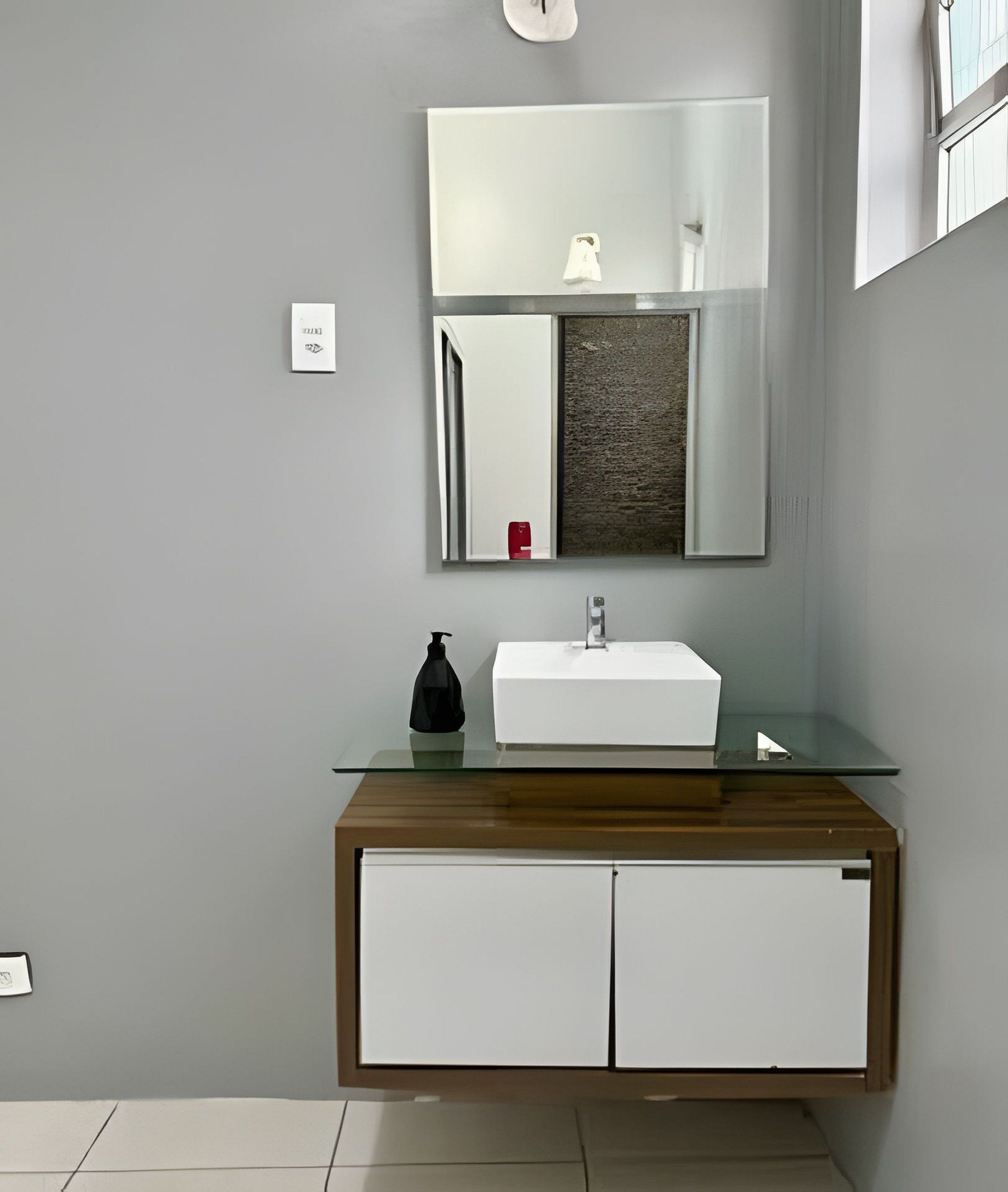 Ein Badezimmer mit Waschbecken, Spiegel und Schrank.