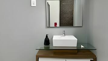 Ein Badezimmer mit Waschbecken, Spiegel und Schrank.