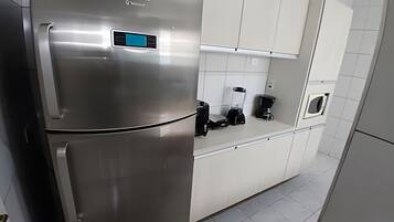 A modern kitchen with a stainless steel refrigerator, a coffee maker, and a microwave.