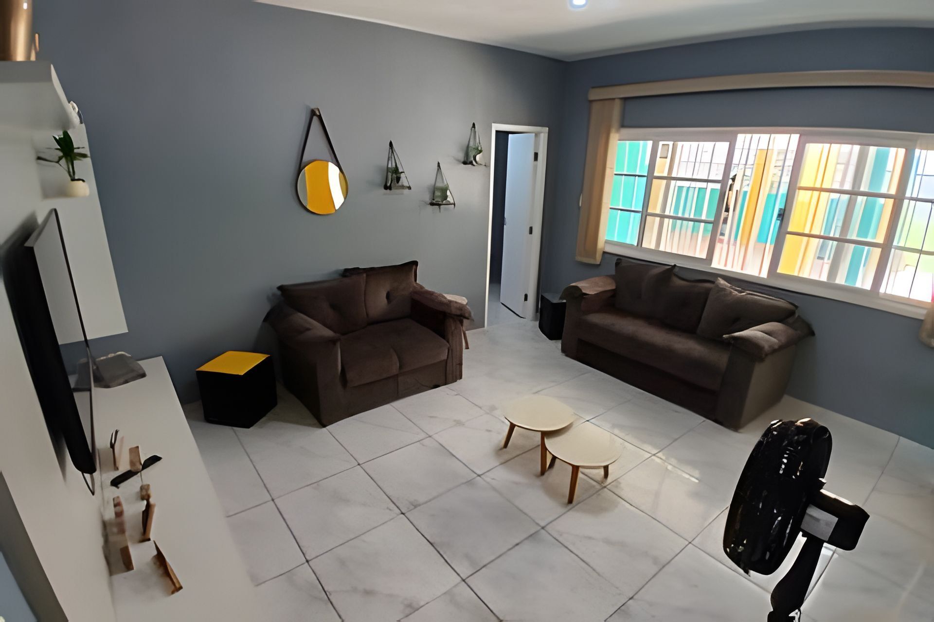 A living room with two sofas, a coffee table, and a TV stand.