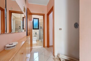 A hotel bathroom with a shower, toilet, and sink.
