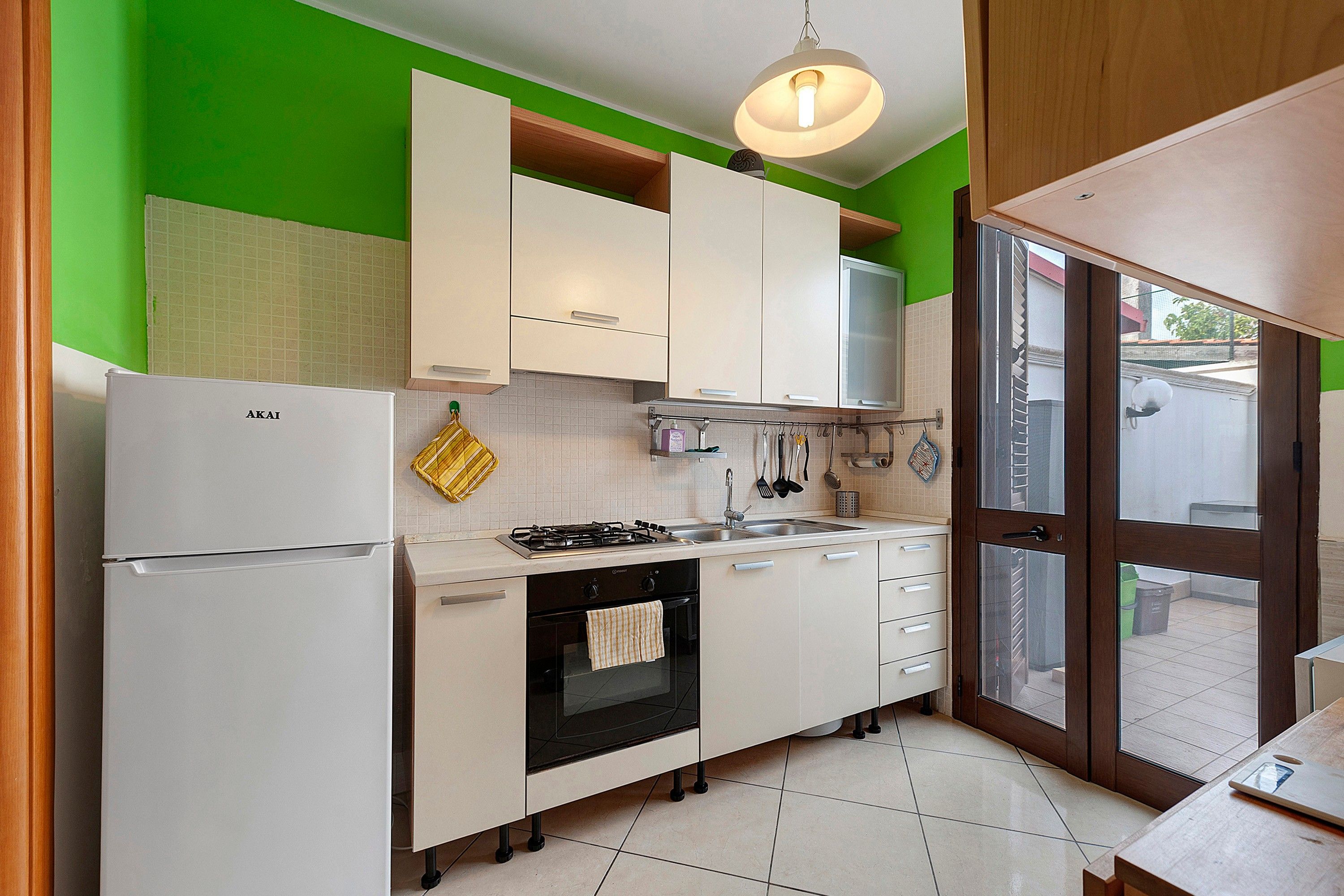 A kitchen with white cabinets, a stove, and a refrigerator.