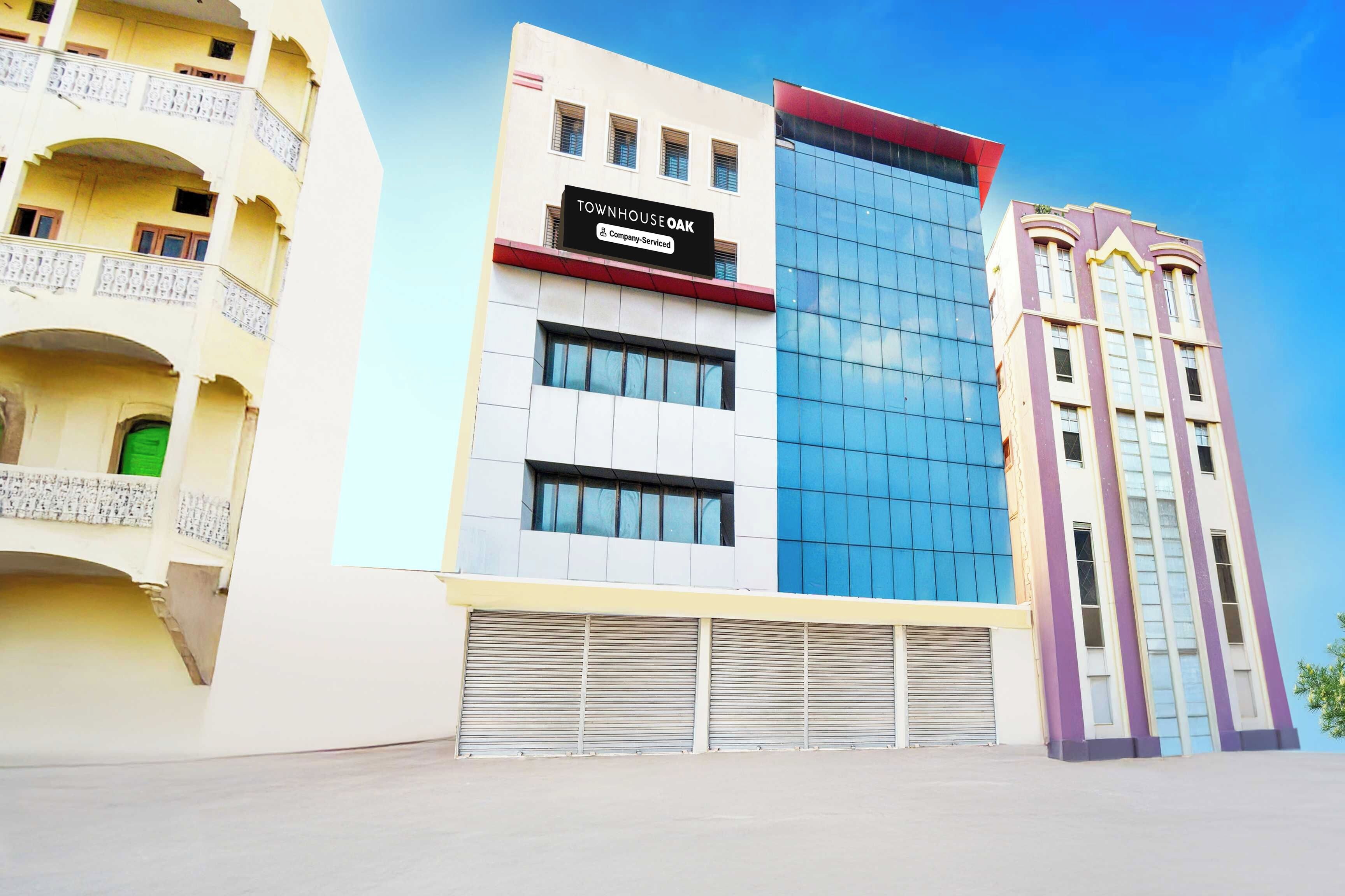 A multi-story building with a sign indicating it is a company-serviced townhouse.