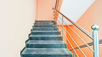 A staircase with metal railings and a handrail, leading upwards.