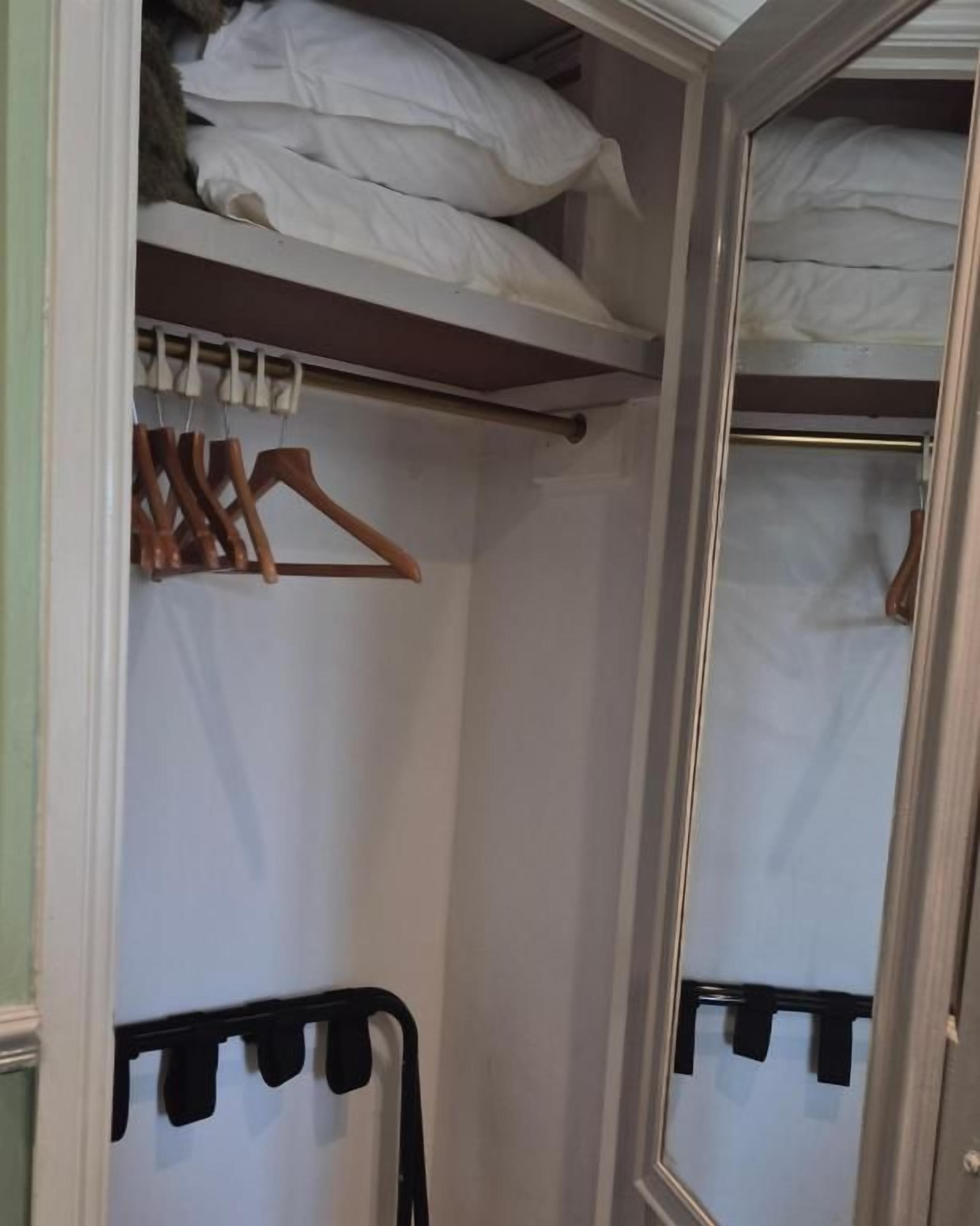 A closet with hanging space, shelves, and a mirrored door.