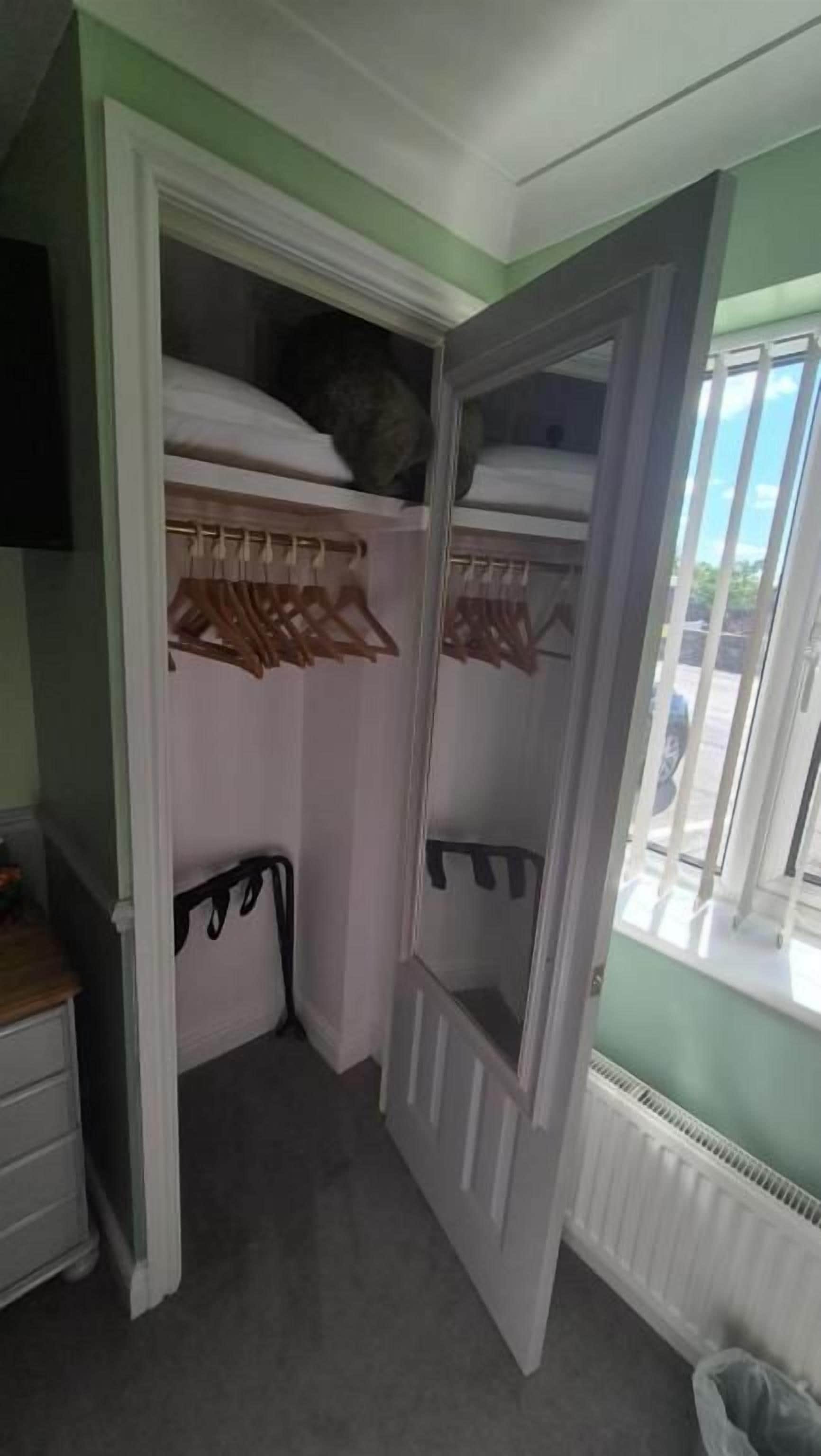 A walk-in closet with hanging space and a mirrored closet door.