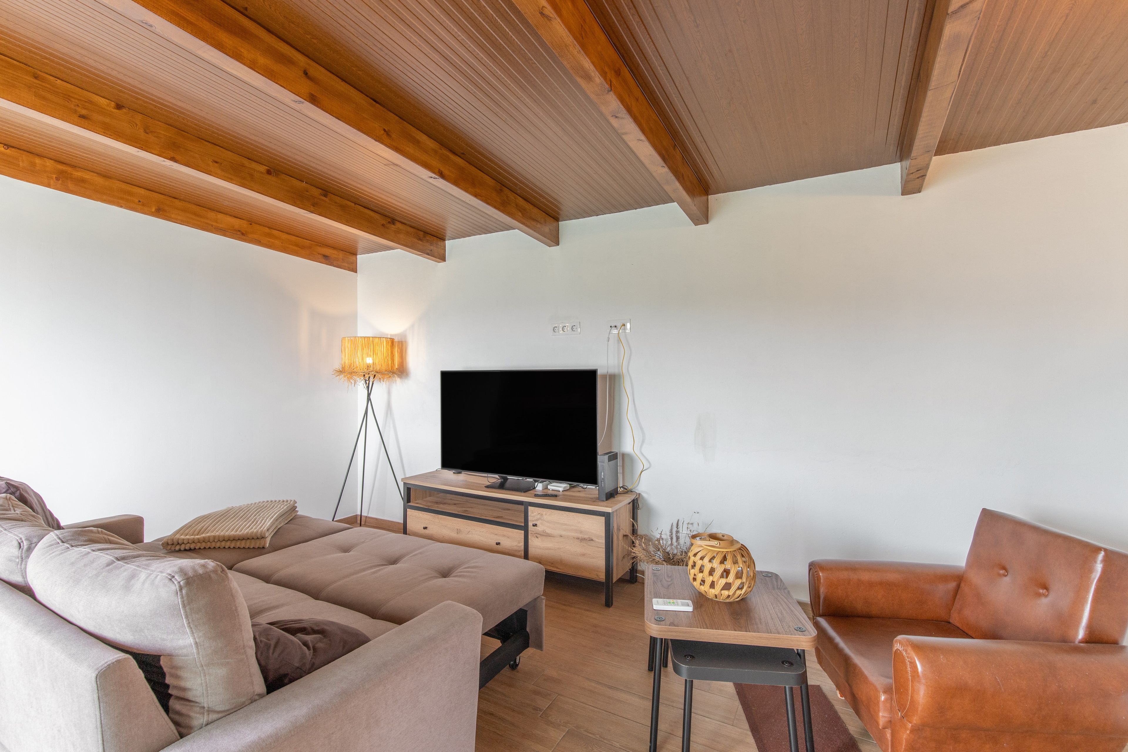 A modern living room with a sofa, a coffee table, and a television.