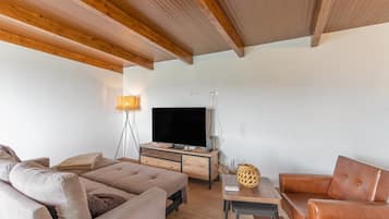 A modern living room with a sofa, a coffee table, and a television.