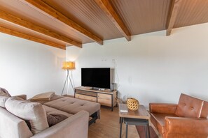 A modern living room with a sofa, a coffee table, and a television.