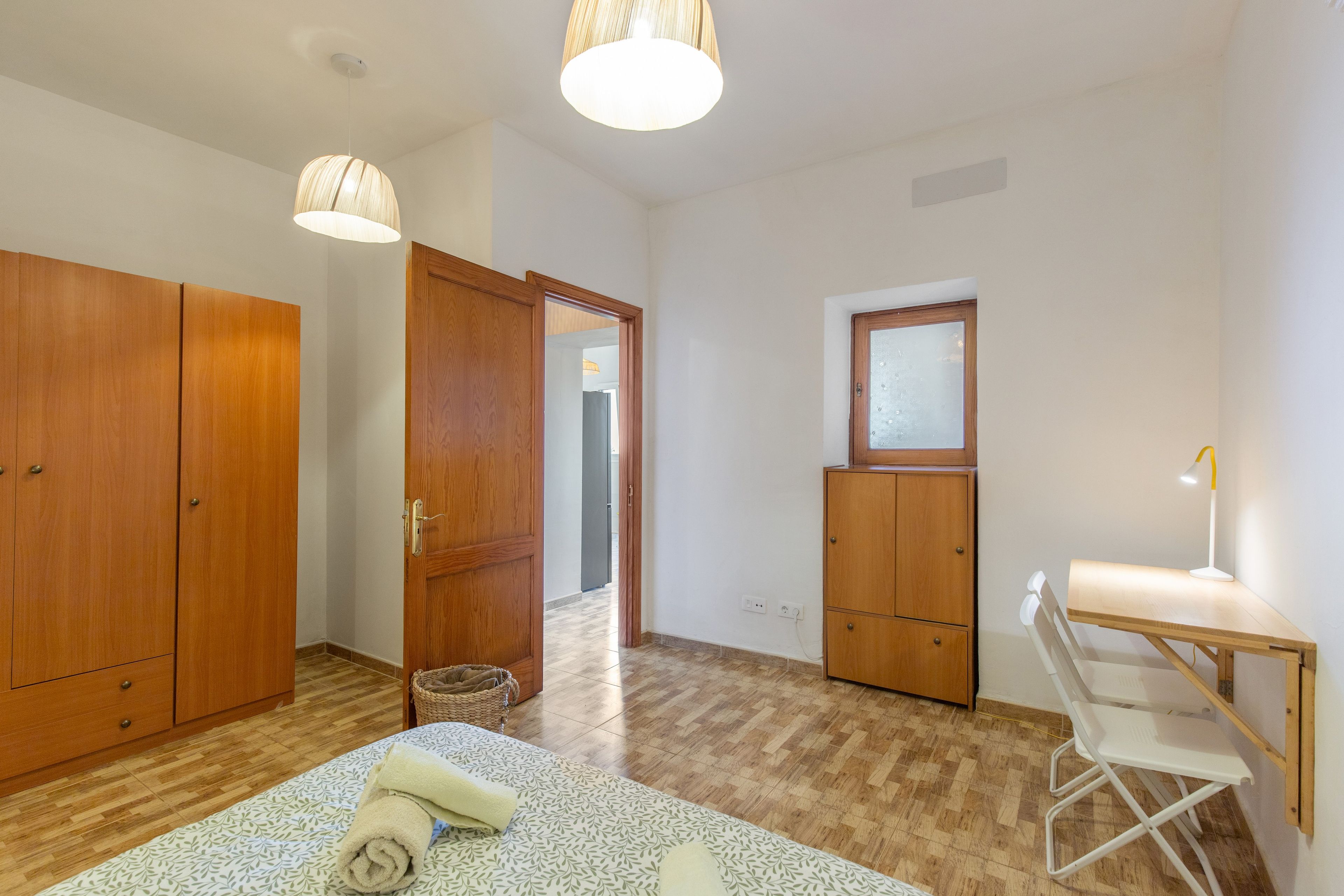 Ein Zimmer mit einem Bett, einem Schreibtisch und einem Kleiderschrank.