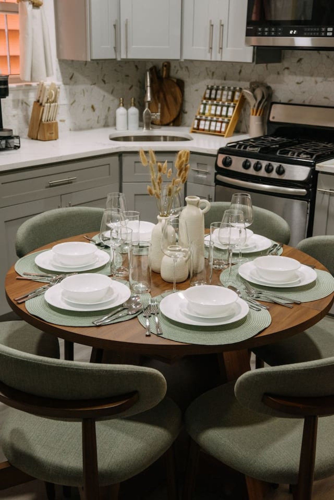 A dining table set for six with a central vase, surrounded by chairs.