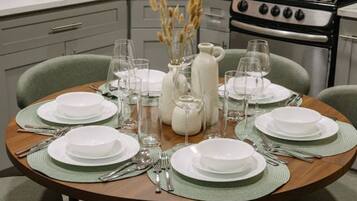 A dining table set for six with a central vase, surrounded by chairs.