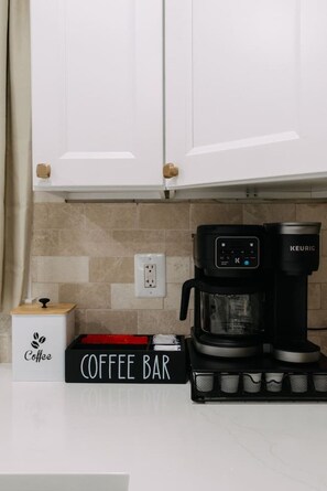 A kitchen with white cabinets, a coffee maker, and a coffee bar sign. - NEW Spacious w/Parking mins NYC & MetLife (North Bergen)