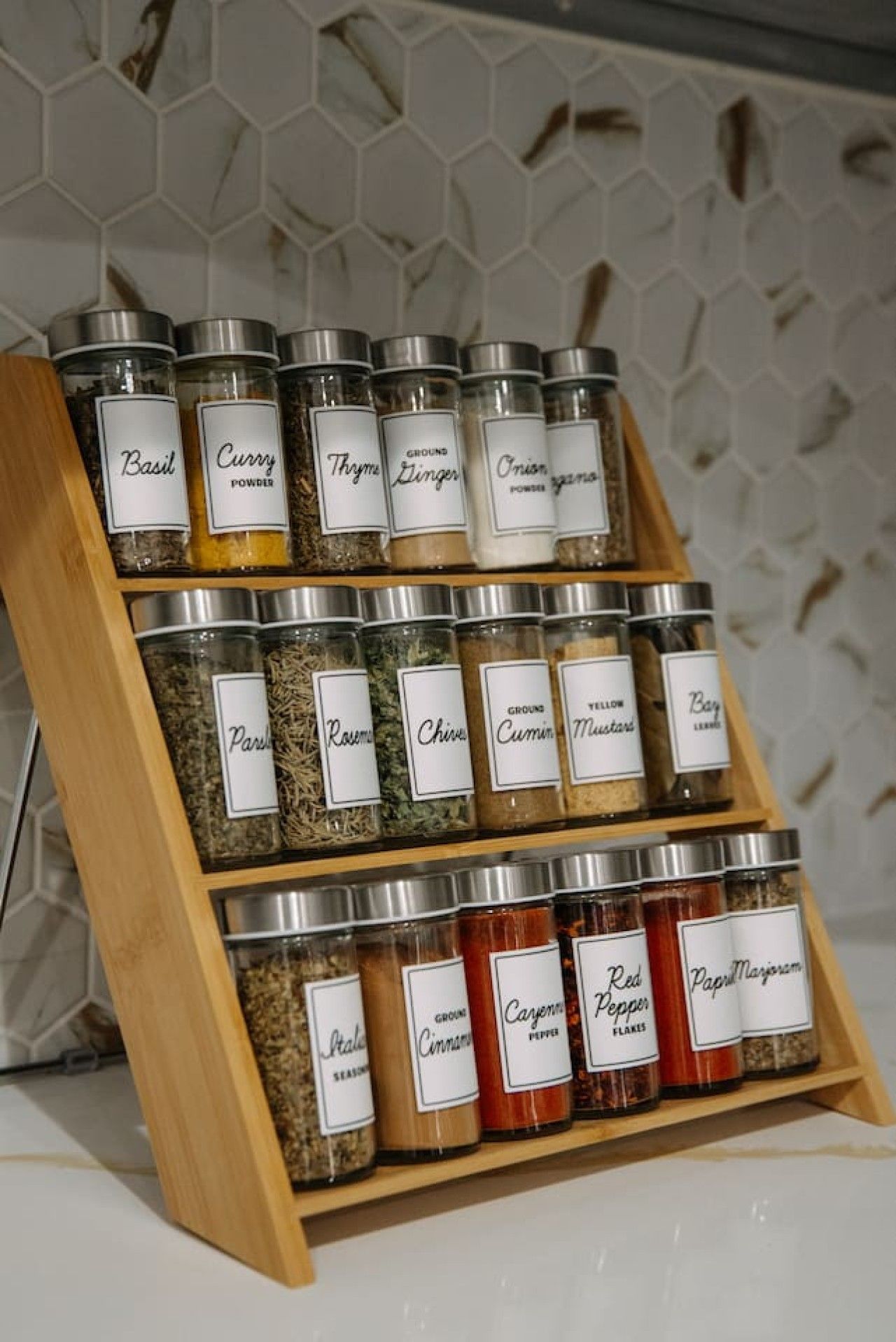 Un mueble de especias con recipientes etiquetados y diferentes tipos de condimentos.