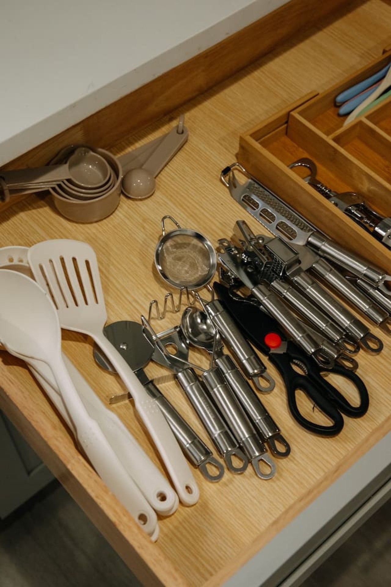 Un cajón de cocina con diversos utensilios y herramientas.