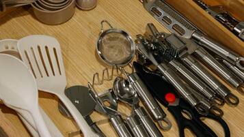 Un cajón de cocina con diversos utensilios y herramientas.